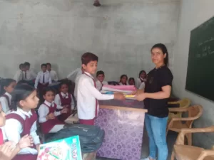 volunteer distributing books for student under sikha sabka aadhikar campaign organised by aapke saath foundation