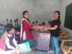 volunteer distributing books for student under sikha sabka aadhikar campaign organised by aapke saath foundation