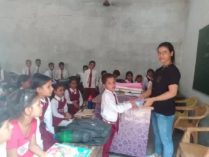 volunteer distributing books for student under sikha sabka aadhikar campaign organised by aapke saath foundation