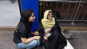 volunteer from aapke saath foundation is sitting with a old age benificerie of blanket distribution campaign during a night of chilly winters