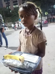 food distribution for a poor slum kid in delhi