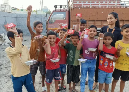 A volunteer from Aapke Saath Foundation NGO celebrating Raksha Bandhan with underprivileged children, all showing their rakhis, happy and smiling.
