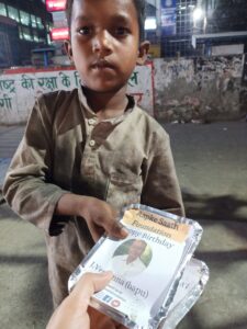 a boy is having food packet on birthday food distribution organised by aapke saath foundation