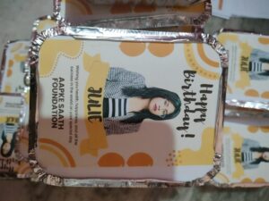 Food packets with a beautifully designed poster featuring a birthday message, a donor's picture, and the AAPKE SAATH Foundation logo.