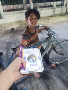 A child receiving a food packet during a birthday celebration organized by AAPKE SAATH Foundation. The event is part of a donor's birthday celebration