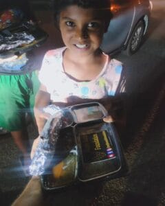 A girl enjoying a meal from the food distribution organized by Aapke Saath Foundation's 'Food for Every Breath' campaign.