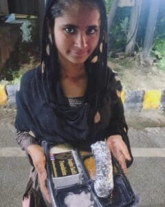 A girl enjoying a meal from the food distribution organized by Aapke Saath Foundation's 'Food for Every Breath' campaign.
