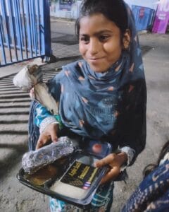 A girl enjoying a meal from the food distribution organized by Aapke Saath Foundation's 'Food for Every Breath' campaign.