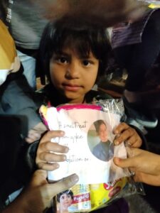 a kids having birthday celebration kit by volunteer.
