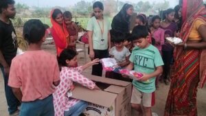 a volunteer distributing celebration kits(Food) for the slum childrens