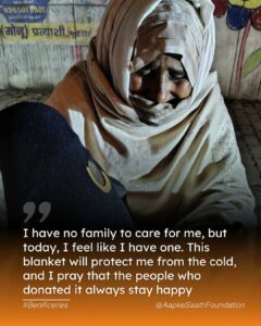 A volunteer hands over a warm blanket to an elderly woman during the winter essentials distribution, ensuring she stays warm in the cold weather.