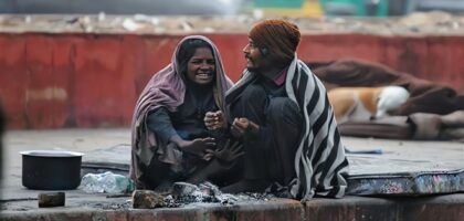 a girl and his fater sitting near to fire to get warn in col weather