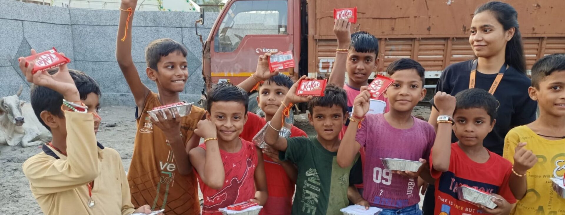 Poor children celebrating Raksha Bandhan with chocolates and food packets from NGO donation drive in India