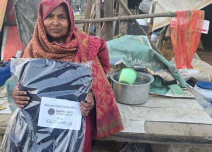 Homeless woman receiving blanket during CloudRock supported winter relief campaign in Delhi